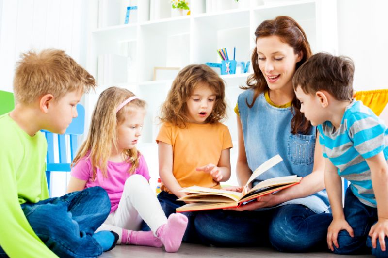 Bambini intorno ad una signora che legge